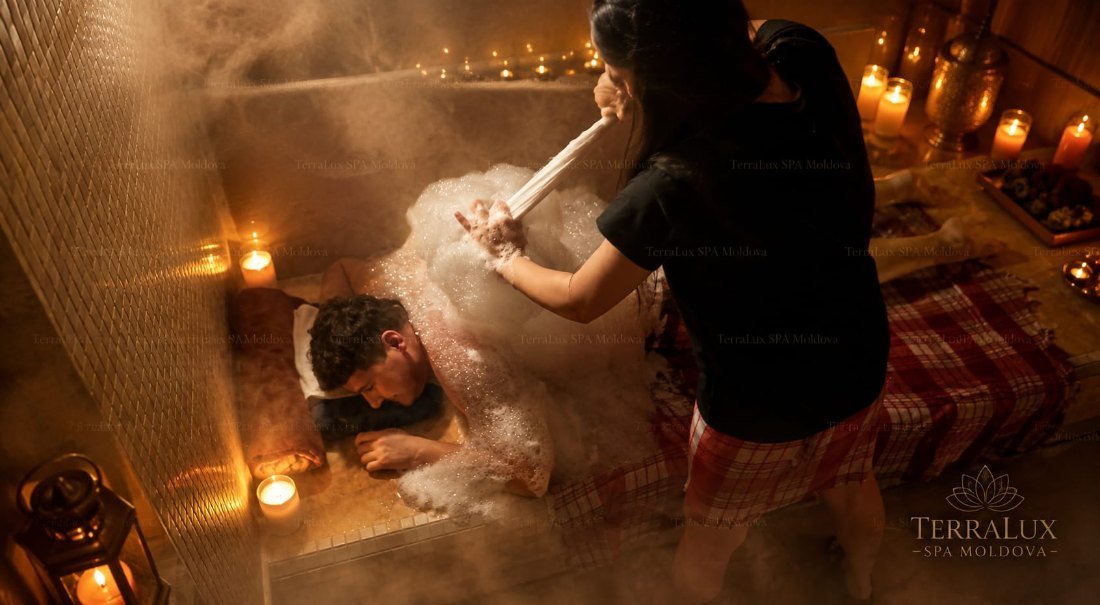 Therapist performing the Köpük foam massage by candlelight in the hammam at TerraLux SPA in Chișinău