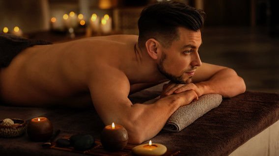 Man resting on the massage table by candlelight at TerraLux SPA in Chișinău